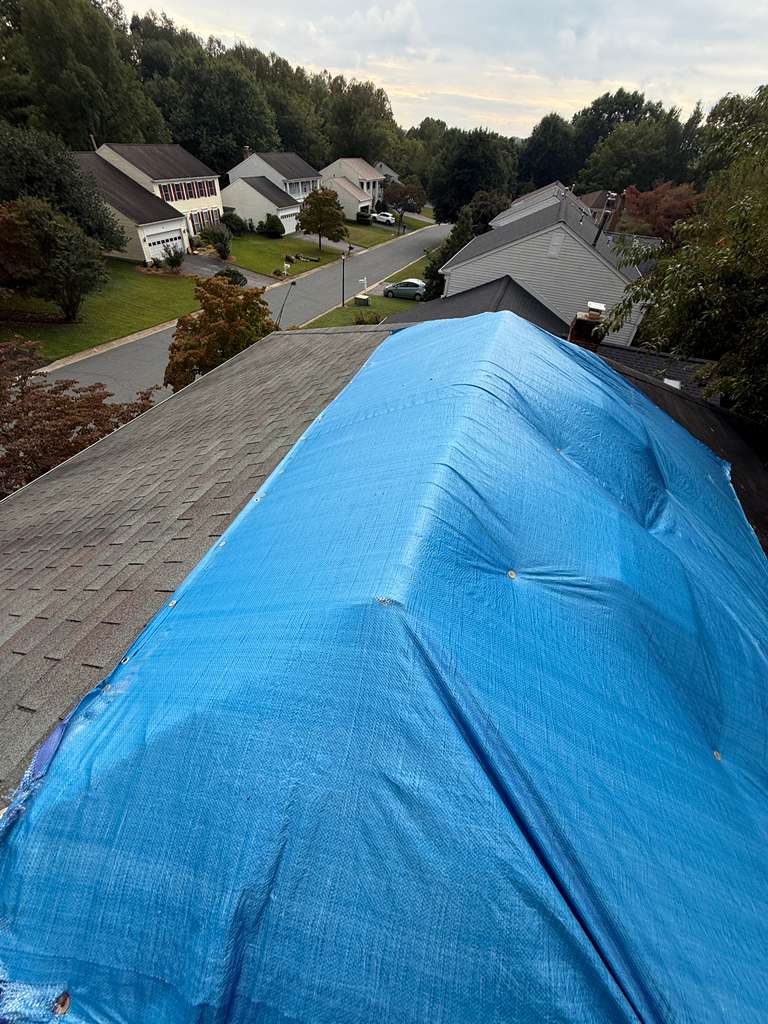 Roofer installing shingles